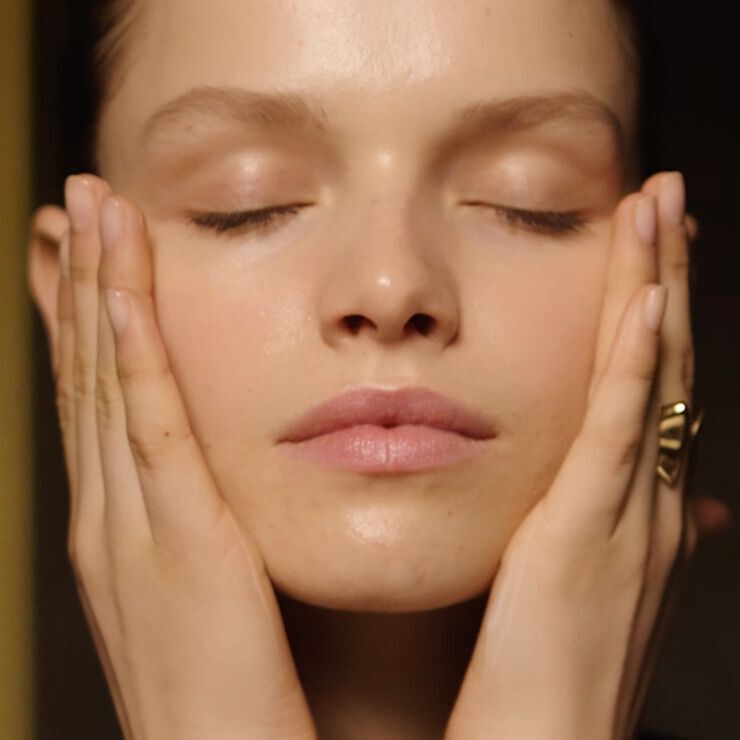 Applying Lancome Absolue L’Extrait Elixir Lotion on face